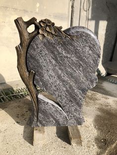 a heart shaped granite sculpture sitting on top of a wooden pallet in front of a building