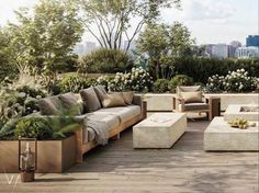 an outdoor living area with couches, tables and potted plants