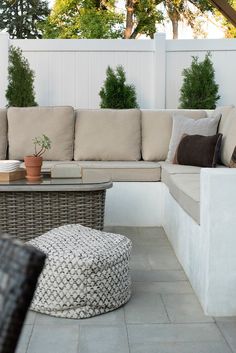 an outdoor living area with couches and tables