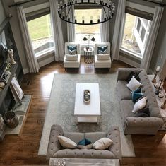 an aerial view of a living room with couches, tables and chandelier