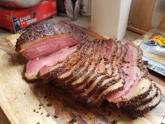 sliced meat sitting on top of a wooden cutting board