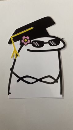 a paper cut out of a penguin wearing sunglasses and a hat with a flower on it