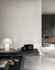 a modern living room with white walls and flooring is pictured in this image, there are two lamps on the table next to the coffee table