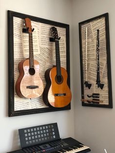 two guitars are hanging on the wall next to a keyboard