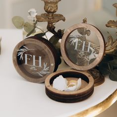 three small wooden boxes sitting on top of a white table next to flowers and candles