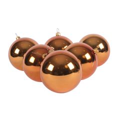 four shiny copper christmas balls on white background