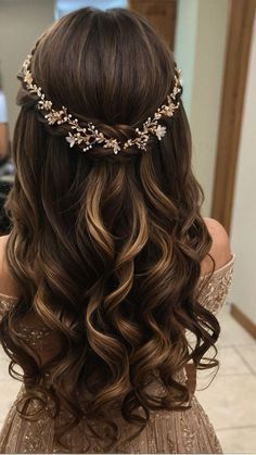 the back of a woman's head with long, wavy hair and flowers in her hair