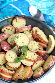 a pan filled with cooked potatoes and garnished with herbs