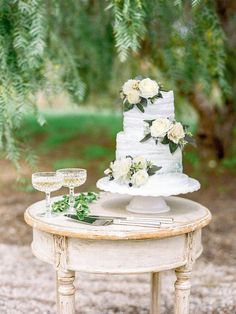 a wedding cake sitting on top of a table next to a wine glass and knife