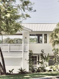 a white house surrounded by trees and plants