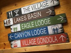 a wooden sign that says the village, lakes basin, eagle lodge, canyon lodge and village gondola