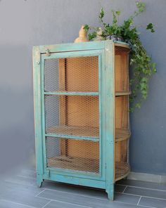 an old blue cabinet with some plants on top