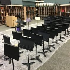 an empty room with rows of chairs and musical instruments on the floor in front of them