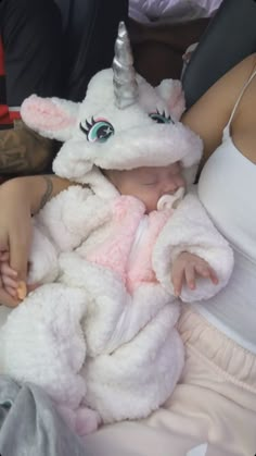 a baby in a unicorn costume is being held by an adult