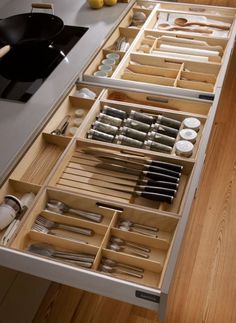 an open drawer in a kitchen filled with utensils