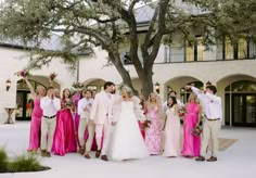 a group of people standing next to each other in front of a tree and building