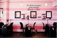 the salon is decorated with pink and white stripes on the walls, along with black chairs