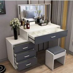 a white and grey vanity with drawers, stools and a mirror on the wall