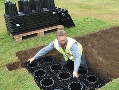 a man is digging in the ground with black tiles