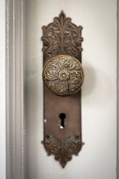 an ornate door handle on a white door