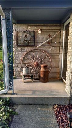 an outdoor room with a wheel on the wall and other items in front of it