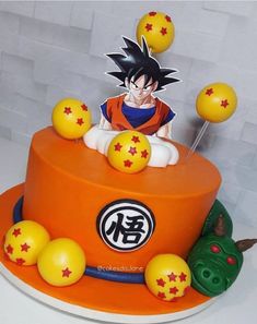 a dragon ball cake is decorated with yellow and red balls on an orange plate,