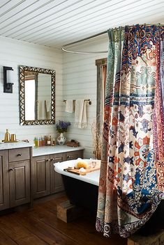 a bath tub sitting under a bathroom window next to a sink