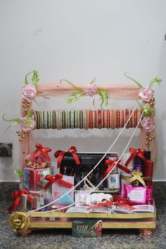 a wooden shelf filled with lots of different types of gift boxes and ribbons on top of it