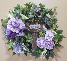 a wreath with purple flowers and green leaves