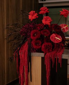 a vase with red flowers in it sitting on a table