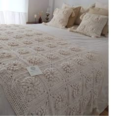 a crocheted bedspread on a bed in a bedroom