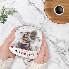 two hands holding a personalized photo ornament