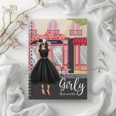 a spiral notebook with an illustration of a woman in a black dress