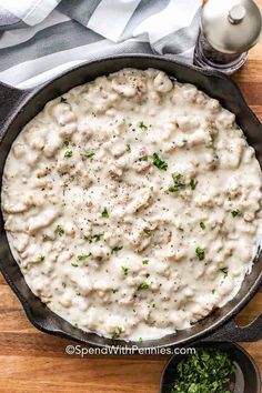 a skillet filled with mashed potatoes and gravy next to some parsley