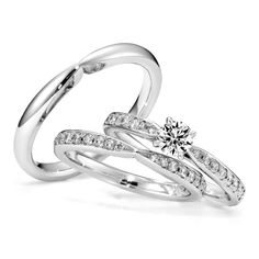 two white gold wedding rings with diamonds on each one and an engagement ring in the middle