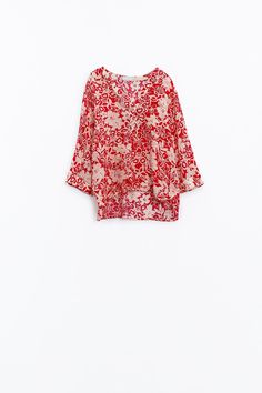 Introducing our Relaxed Red Floral Print Blouse with Bell Sleeves, a perfect blend of comfort and style for your spring and summer wardrobe. Crafted from lightweight chiffon fabric, this blouse offers a breezy and flowy silhouette, ensuring maximum comfort on warm days.  Featuring a 70's inspired floral print and bell sleeves, this blouse exudes boho-chic vibes, adding a touch of retro flair to your look. The V-neck neckline and relaxed fit further enhance the laid-back and effortless aesthetic of this piece.  With its versatile design, this blouse is ideal for pairing with denim shorts for a casual and stylish ensemble. Whether you're heading to a weekend brunch or strolling along the beach, this blouse is sure to keep you looking and feeling fabulous.  Made from 70% viscose and 30% polye Silk V-neck Printed Tops, Flowy Chiffon Blouse With Floral Print, Spring Chiffon V-neck Blouse, Summer Silk Blouse For Beach, Silk Summer Blouse For Beach, Spring Bohemian Silk Blouse, Spring Bohemian Silk Tops, Summer V-neck Rayon Blouse, Bohemian Silk Blouse For Spring