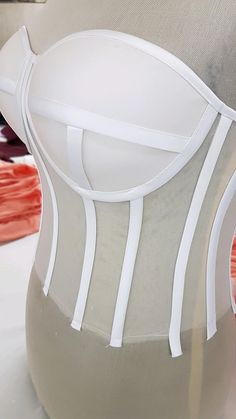 a woman's white corset is displayed on a mannequin