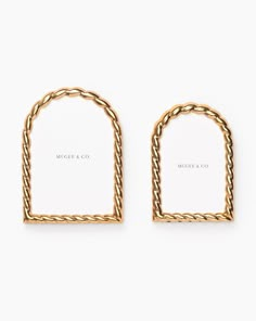 two gold earrings with rope details on each side and a white card in the middle