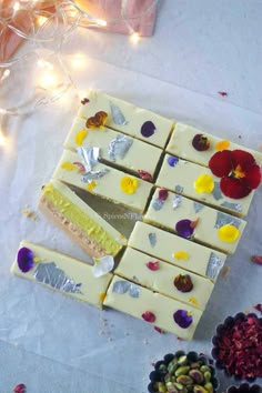 several pieces of cake sitting on top of a table next to flowers and tinsel