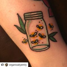 a jar with flowers and leaves on the arm