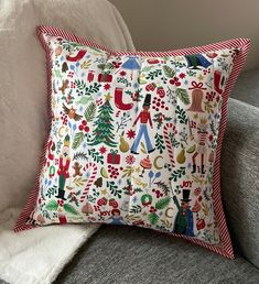 a christmas themed pillow sitting on top of a couch