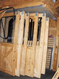 the inside of a barn with wooden doors and metal bars attached to each side of the door