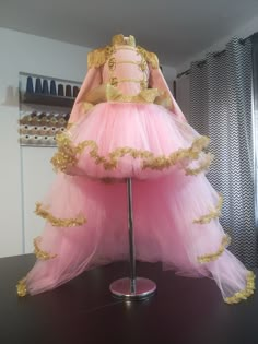 a pink and gold dress sitting on top of a table