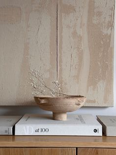 a wooden bowl sitting on top of two books