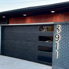 a black garage door with the number 2091 on it's side and an open window