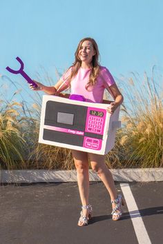 a woman is holding a pink and black radio with a wrench in her hand