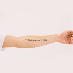 a woman's arm with flowers on it and the word love written in cursive writing