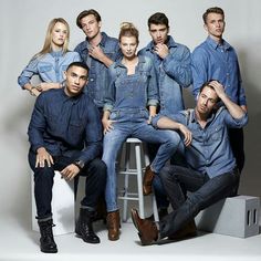 a group of people sitting on top of a stool next to each other in front of a white background