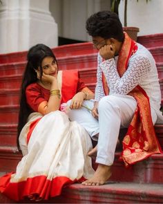 a man and woman are sitting on the steps