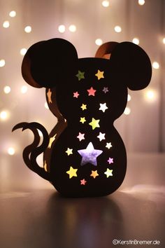 a mickey mouse lamp with stars on it's face and the shape of a mouse